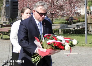Delegacja osób podczas składania wiązanki kwiatów.