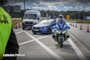 Policyjny motocyklista zatrzymuje pojazd do kontroli drogowej.