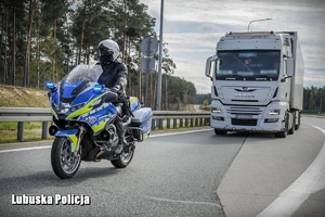 policjant na motocyklu zatrzymuje ciężarówkę