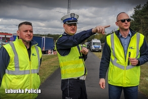 policjant wskazuje kierunek mężczyznom