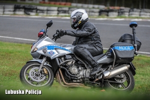 policjant na motocyklu jedzie po torze