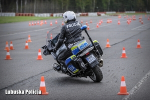 Policyjny motocyklista pokonuje przeszkody na torze