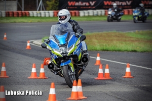 Policyjny motocyklista pokonuje przeszkody na torze