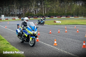 Policyjny motocyklista pokonuje przeszkody na torze