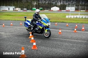 Policyjny motocyklista pokonuje przeszkody na torze