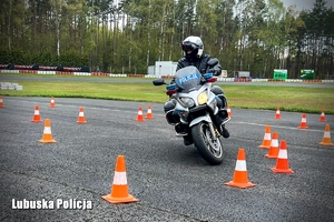 Policyjny motocyklista pokonuje przeszkody na torze