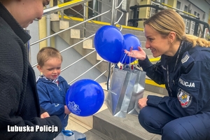 policjantka wręcza chłopcu upominki