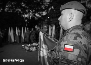 Czarno białe zdjęcie przedstawiające żołnierza podczas uroczystości rocznicowych.
