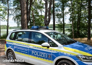 Radiowóz policyjny z Niemiec zaparkowany w lesie.