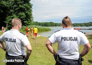 Policjanci podczas obserwowania ćwiczeń ratowniczych na jeziorze.