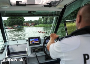 Policjant podczas prowadzenia motorówki na wodzie.