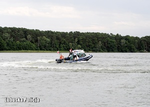 Policyjna motorówka płynie po jeziorze.
