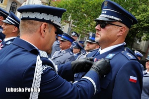 I Zastępca Komendanta Głównego Policji przypina odznaczenie policjantowi.