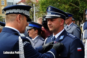 I Zastępca Komendanta Głównego Policji przypina odznaczenie policjantowi.