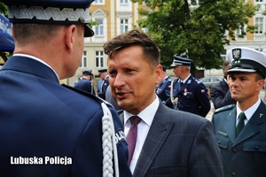 Policjant odbiera gratulacje od mężczyzny.