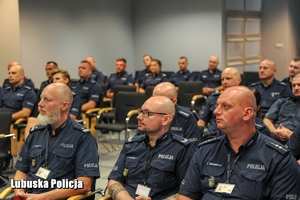 policjanci siedzą na sali