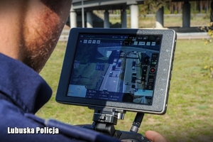 policjant steruje dronem