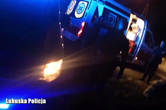 Policjanci zmierzający w stronę karetki pogotowia.