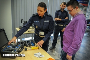 policjantka demonstruje chłopcu wyposażenie służbowe