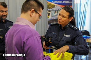 policjantka wręcza chłopcu odblaski