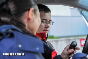 policjantka rozmawia z chłopcem w radiowozie