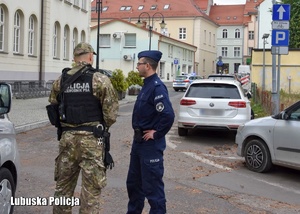 Policjanci rozmawiają przed budynkiem uczelni.