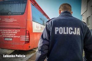 Policjant idący w kierunku krwiobusa.