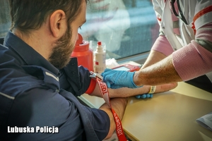 Policjant podczas badania przed pobieraniem krwi.