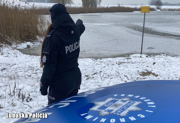 policjantka stoi przy zbiorniku wodnym