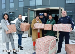 policjanci i kobiety niosą paczki