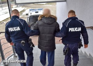Policjanci prowadzą zatrzymanego