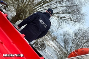 policjant stoi przy motorówce