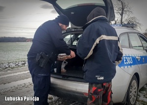 policjant przekazuje herbatę bezdomnemu