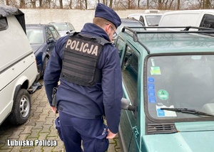 Policjant przy zabezpieczonych pojazdach