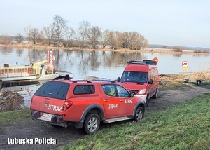 Pojazdy straży pożarnej nad rzeką.