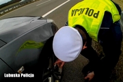 Policjant ruchu drogowego zmienia koło w samochodzie