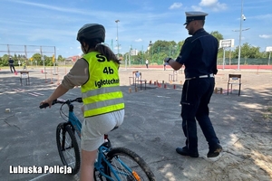 policjant przygląda się uczniowi biorącemu udział w konkursie