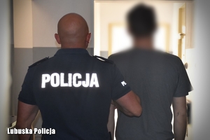 Policjant prowadzi zatrzymanego