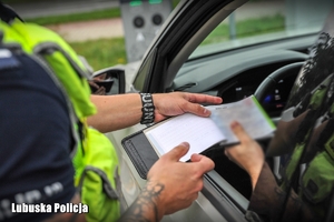 Policjant ruchu drogowego wystawia mandat