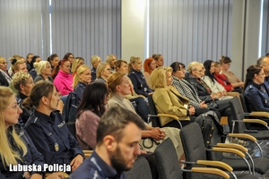 osoby siedzą na sali konferencyjnej