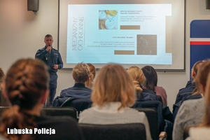 osoby siedzą na sali konferencyjnej