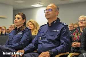 osoby siedzą na sali konferencyjnej