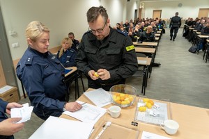 Policjant losuje kolejność w konkursie