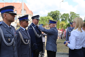 Przewodniczący NSZZP przypina odznaczenie Komendantowi