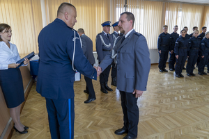 Komendant wręcza list gratulacyjny policjantowi