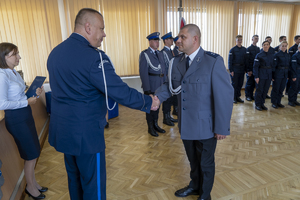 Komendant wręcza list gratulacyjny policjantowi