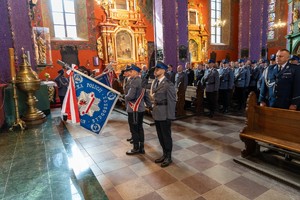 Policjanci trzymają sztandar policji