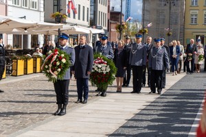 Uczestnicy uroczystości składają kwiaty pod pomnikiem