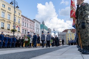 Uczestnicy uroczystości składają kwiaty pod pomnikiem