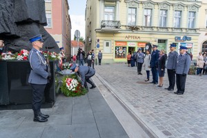 Uczestnicy uroczystości składają kwiaty pod pomnikiem